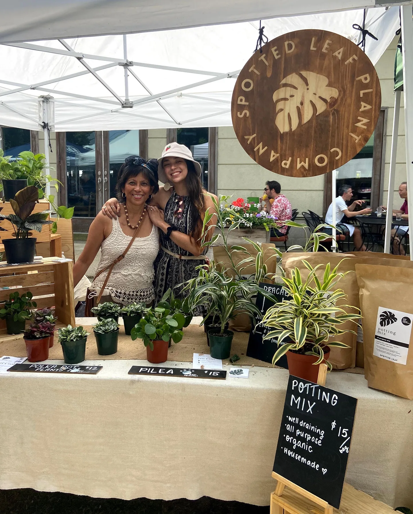 Owner Sam Shaw and her mother posing behind pop-up booth