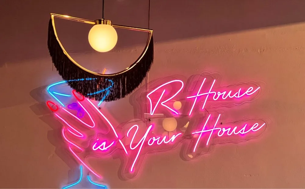 Photo of a neon sign at R House that says "R House is Your House" from Yelp user Jazmin G.