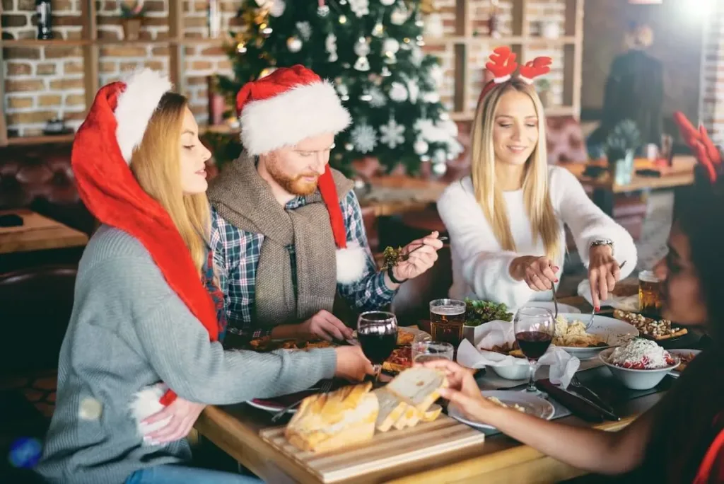 Family wearing Christmas hats while having dinner at a restaurant