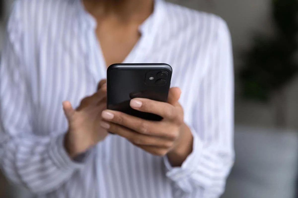 A woman browsing a mobile-friendly website on her phone with an easy-to-use navigation menu