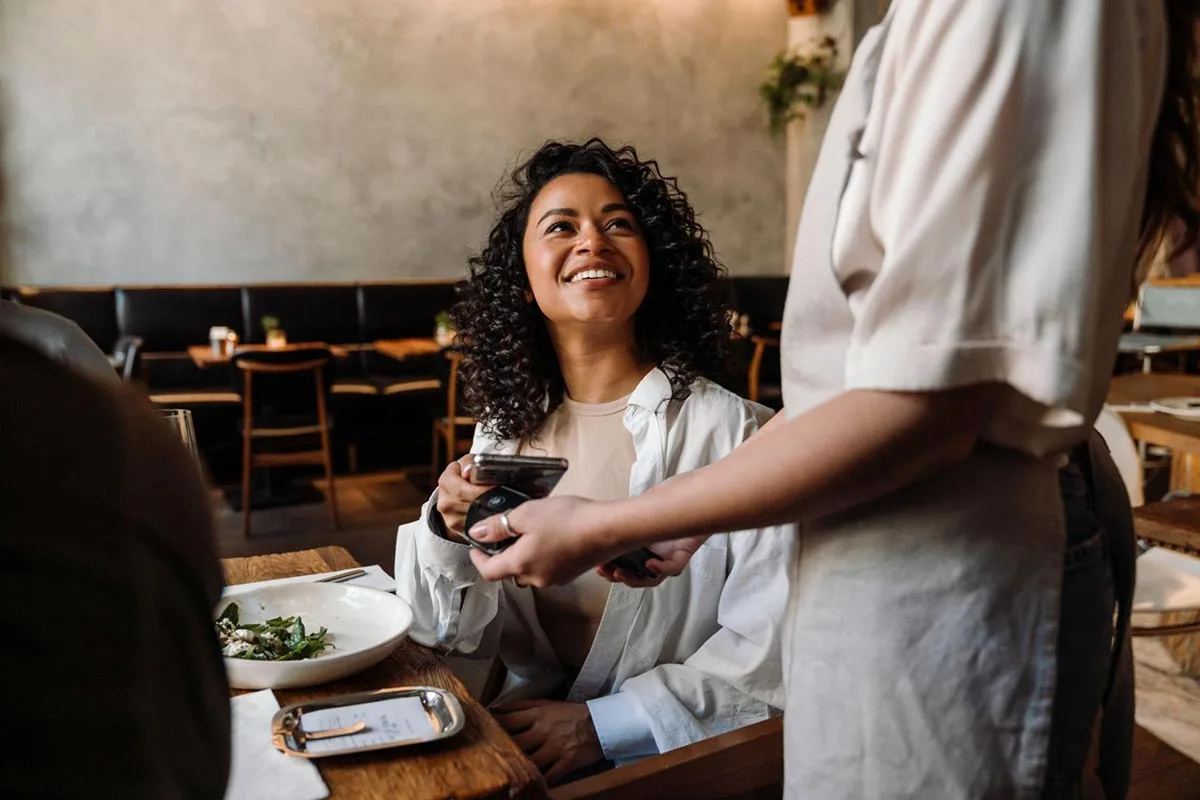 A customer making a payment with a card to settle their meal at a restaurant