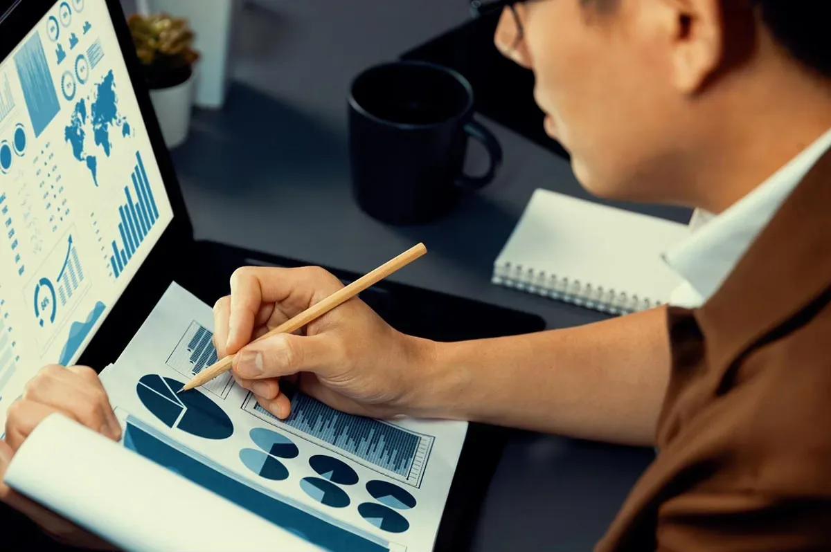 A marketing agency manager analyzing a report on a laptop