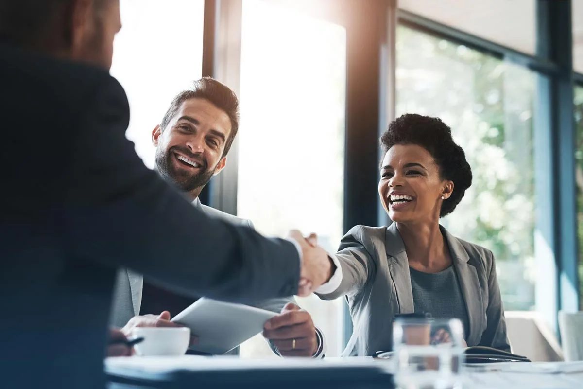 Two marketing executives shaking hands during a meeting