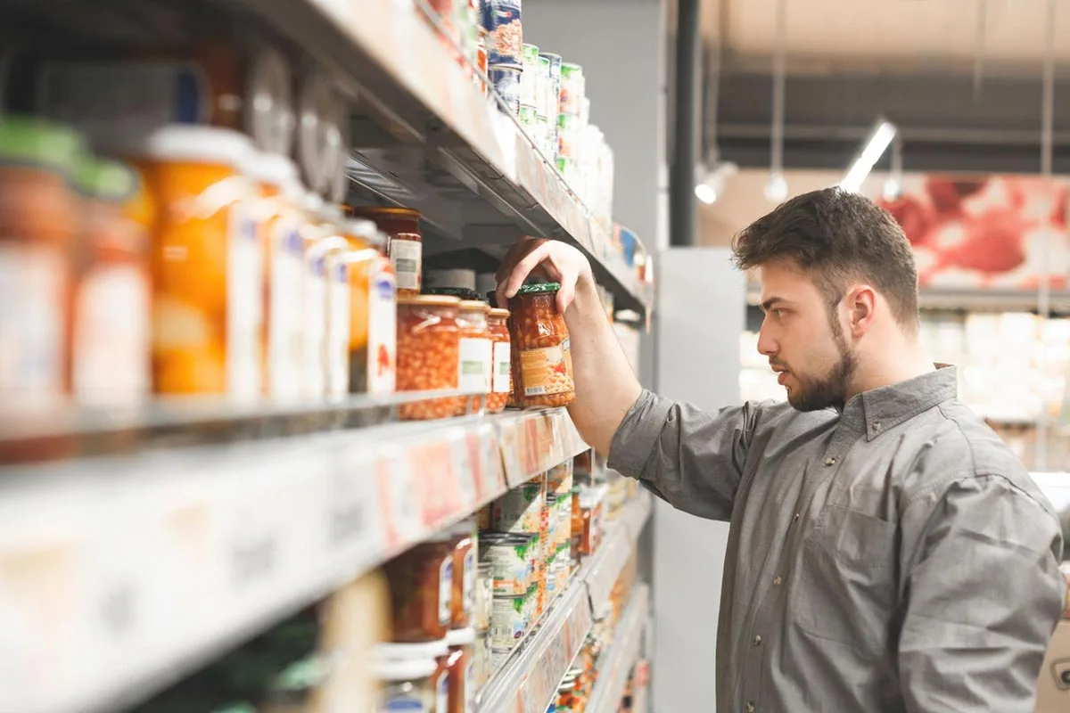 A local grocery shop owner stocking shelves, organizing items neatly for customers.