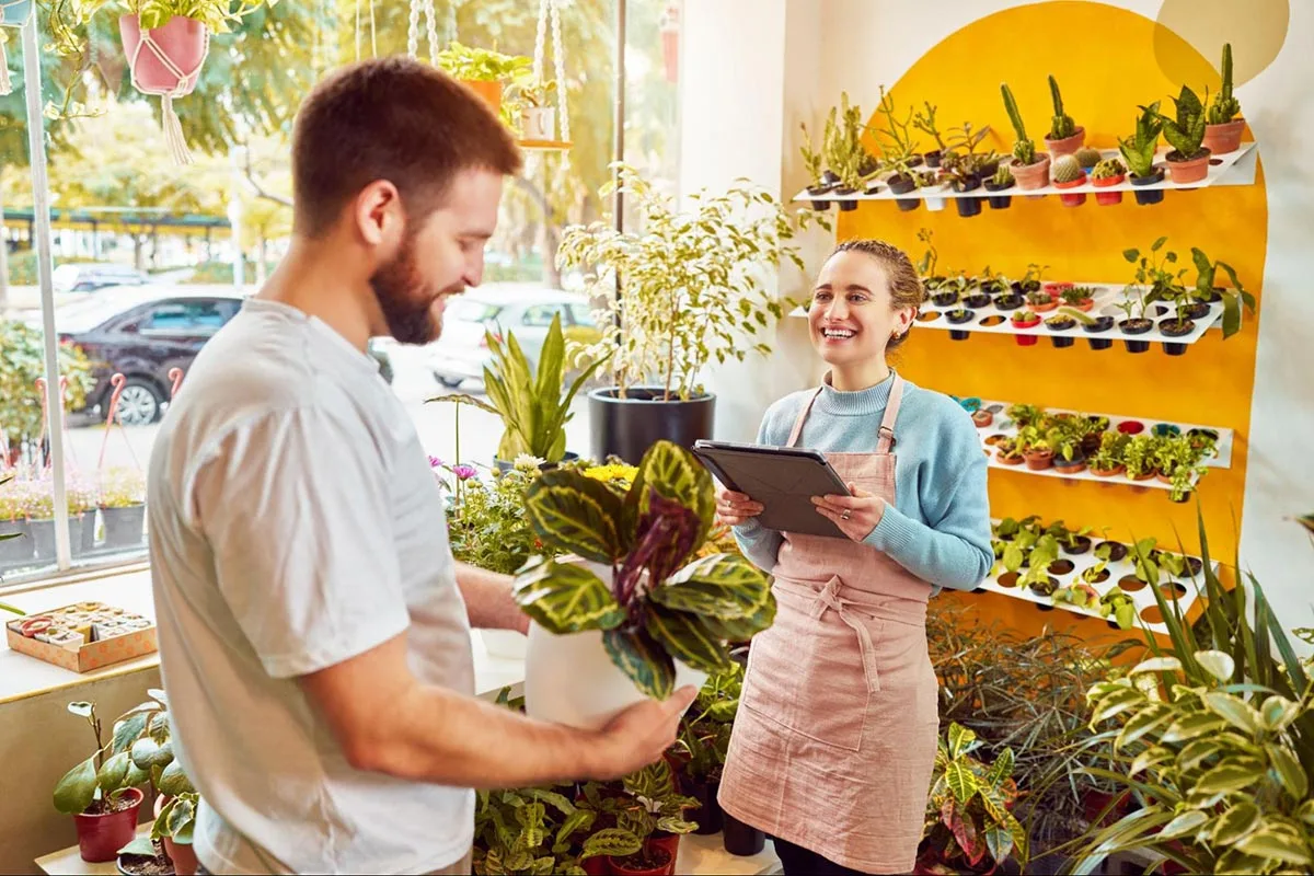 A florist local business owner talking to a customer in the shop.