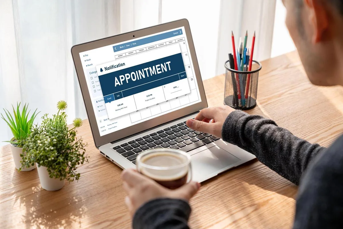 Last-touch attribution: A man sitting at a desk using a laptop to book a business appointment online