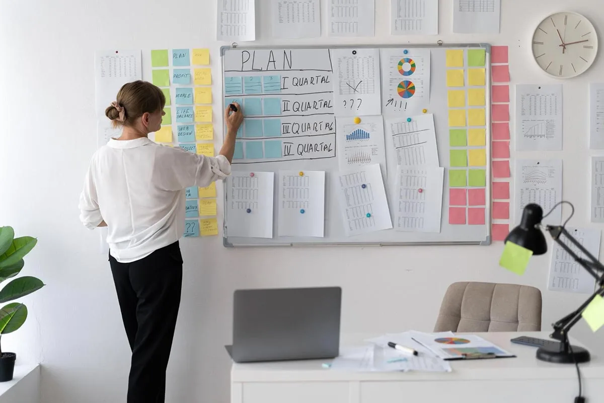  A marketing professional organizing colorful sticky notes on a whiteboard, planning strategies and ideas.