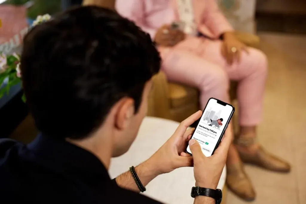 A customer using the Yelp app on a smartphone to book a restaurant table.