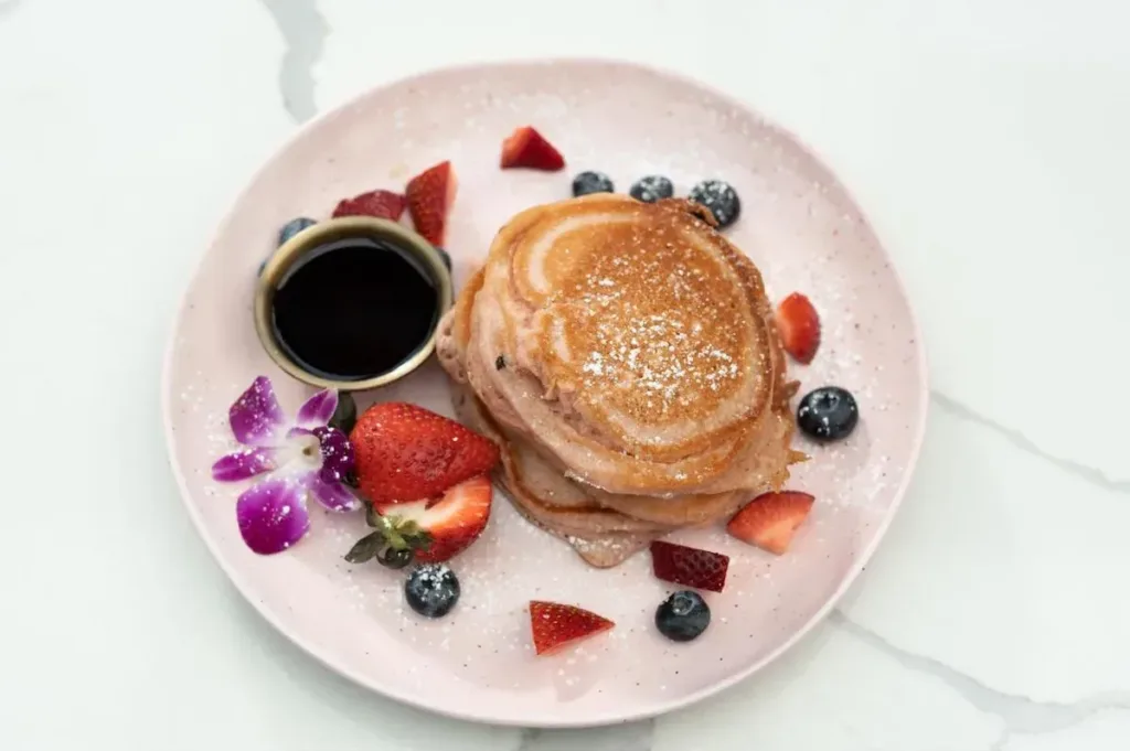 A plate of fluffy pancakes served with mixed berries.