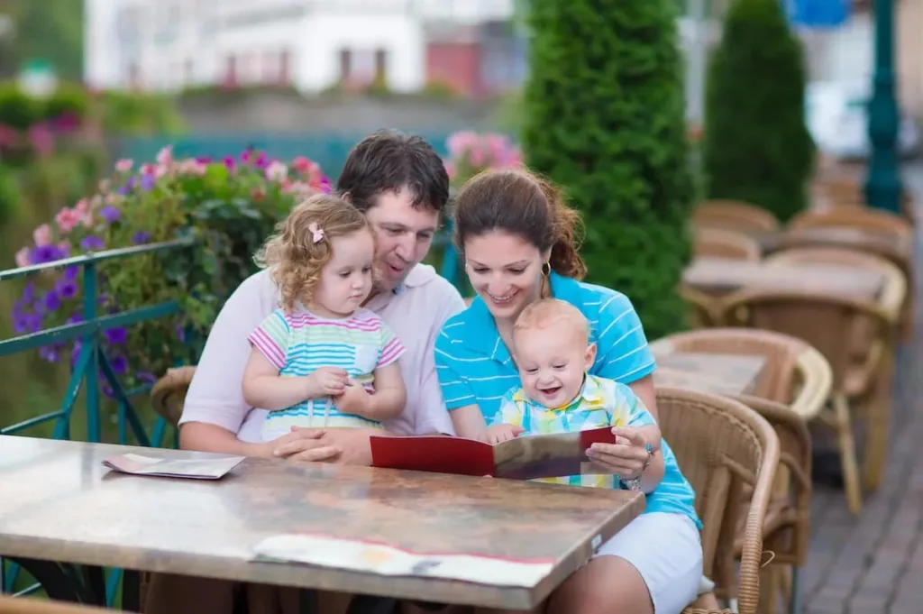 A young family smiling and enjoying their time together at a cozy restaurant.