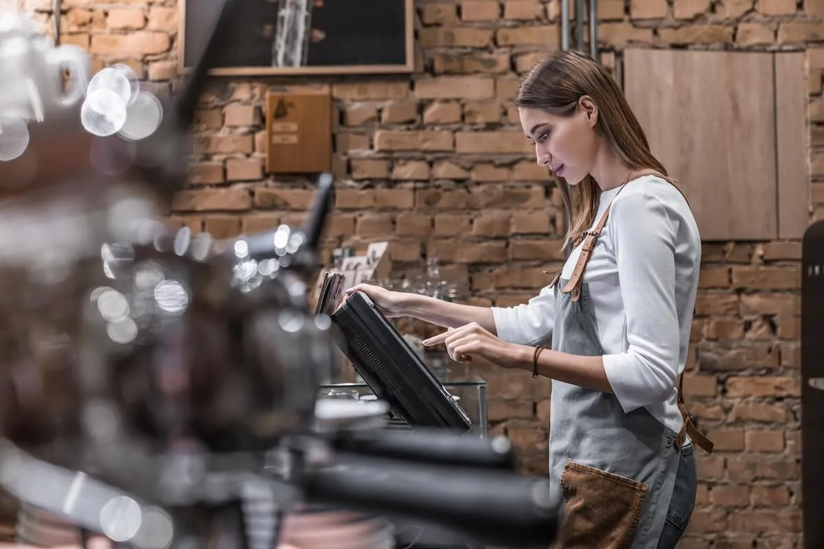 Restaurant management software: cashier using a POS system