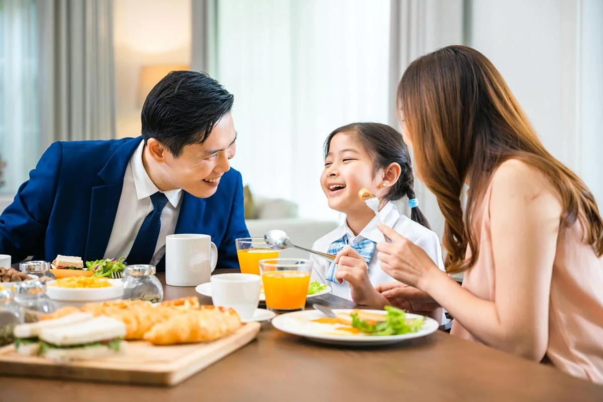 A young daughter telling a funny joke to her father at a restaurant while celebrating Fathers Day.