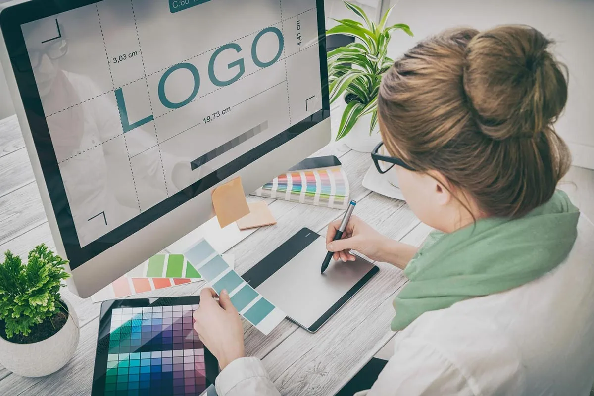 A designer creating a small business logo using a graphics tablet.
