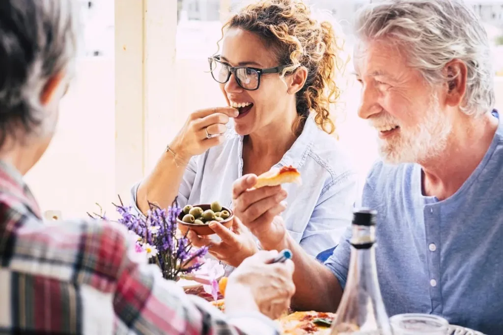 Father and daughter eating together with family at restaurant celebrating Father's Day.