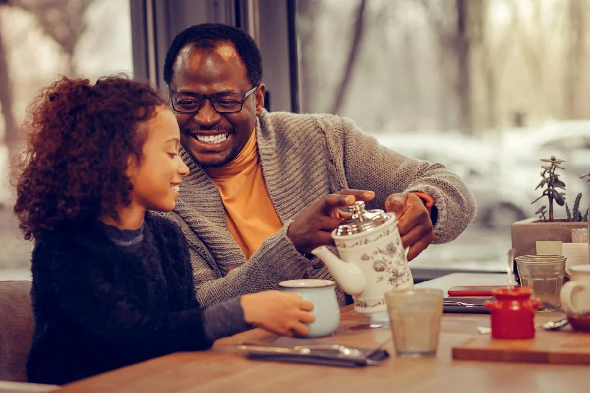 Father and daughter drinking tea together at a restaurant.