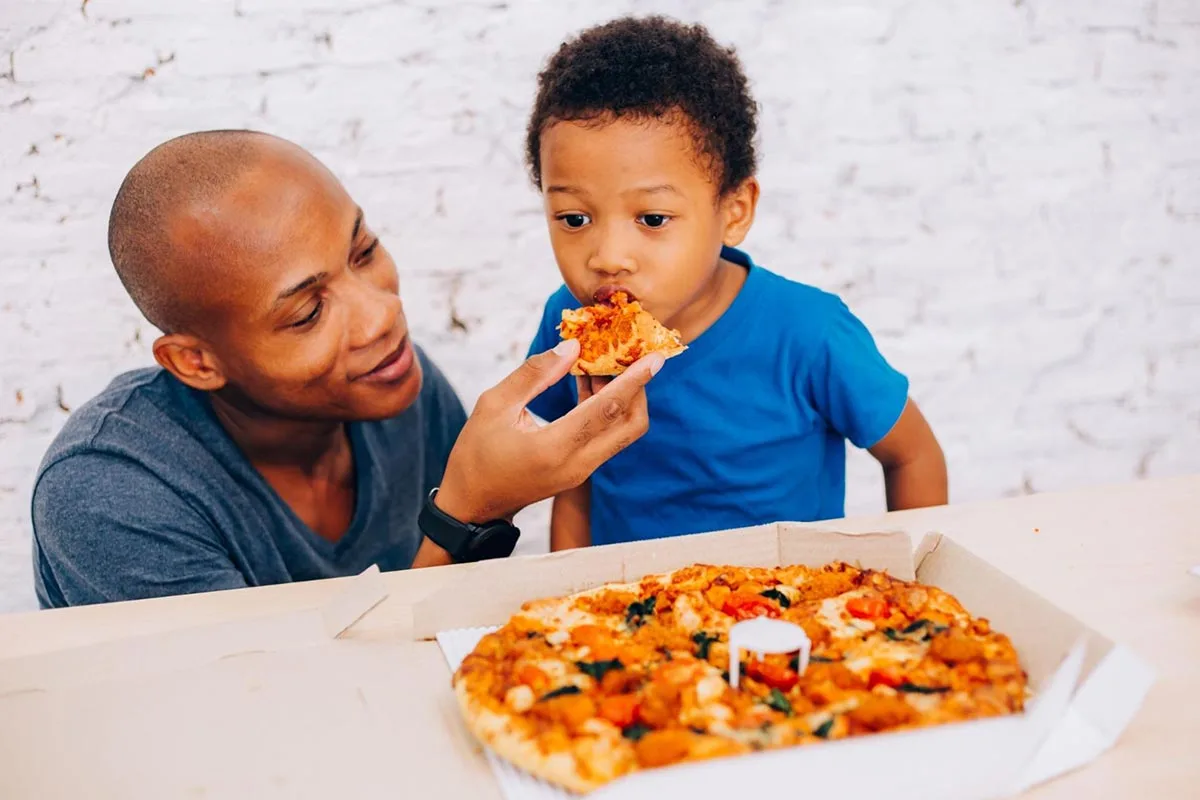 ather and young son enjoying a meal together with their family at a restaurant on Fathers Day.