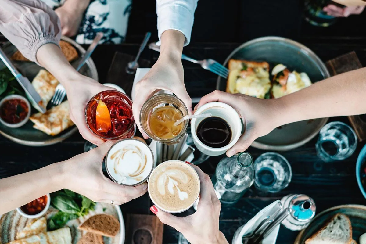 Group of friends toasting drinks together at a restaurant.