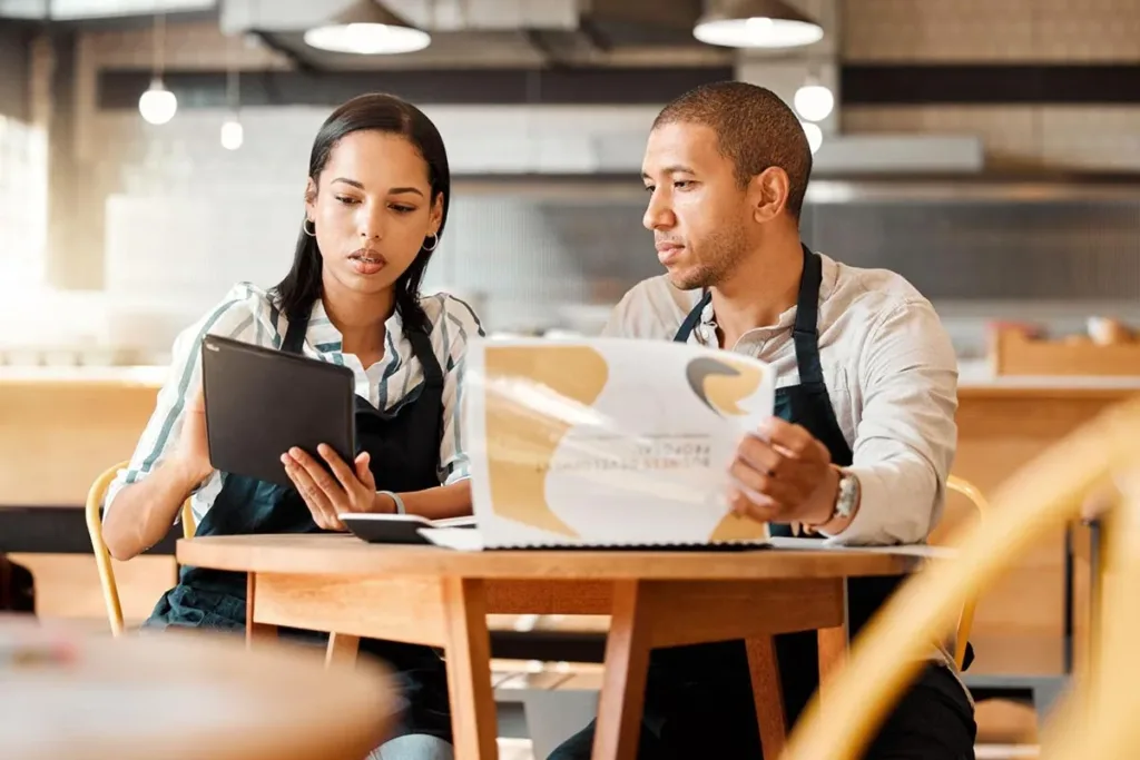 Cafe owners using restaurant table management system.
