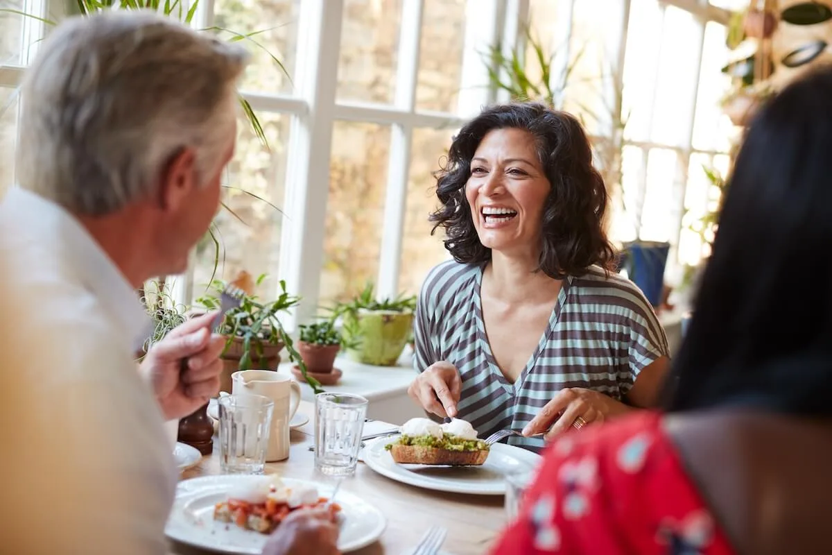 Table turnover rate: woman laughing while talking to an old man at a restaurant