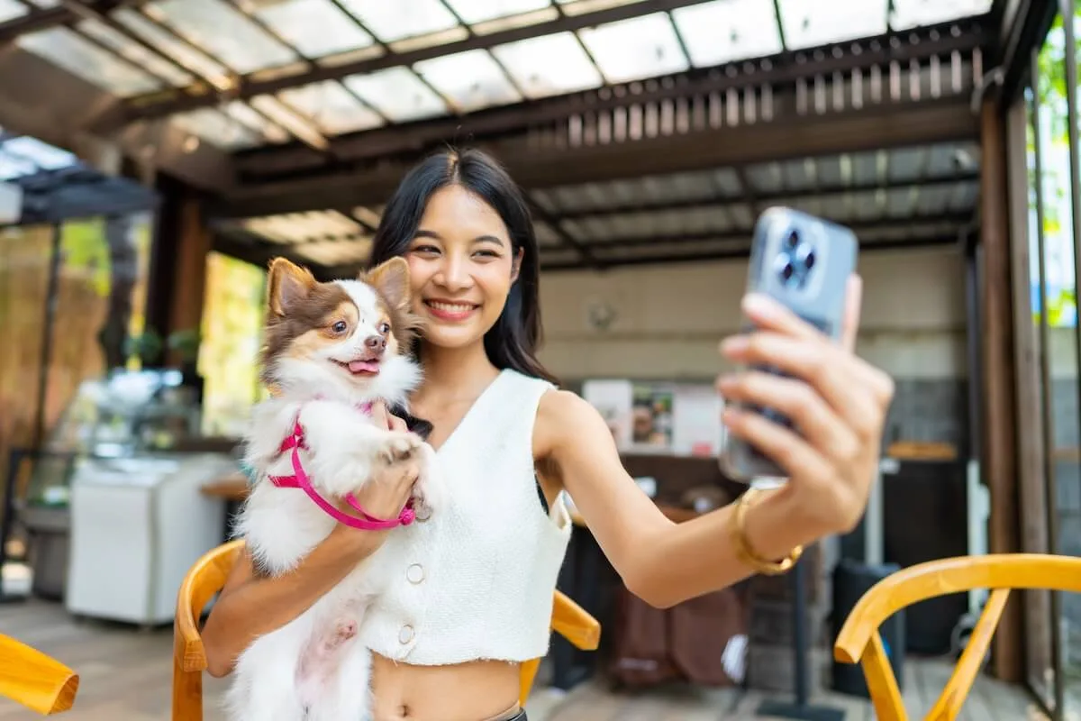 Increase restaurant reservations using social media: woman taking a selfie with her dog