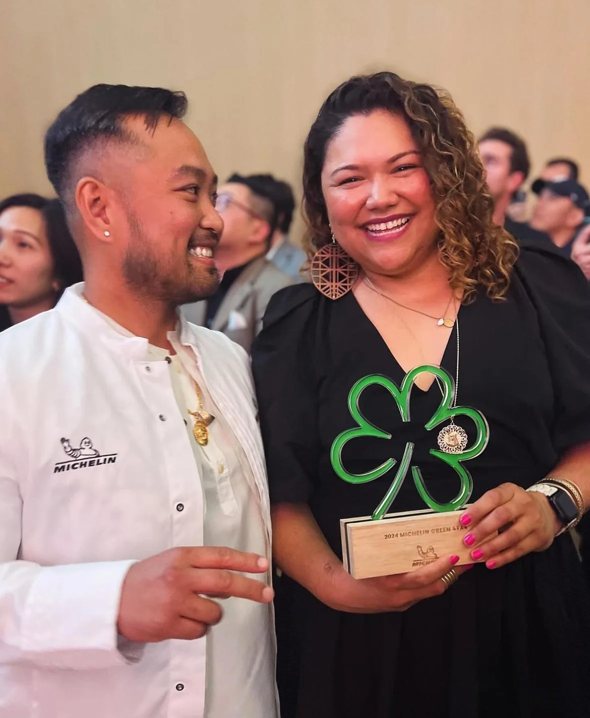 Photo of Kaya Executive Chef Lordfer Lalicon next to co-owner Jamilyn Salonga Bailey, who is holding the restaurant's Michelin Green Star award by John Rife.