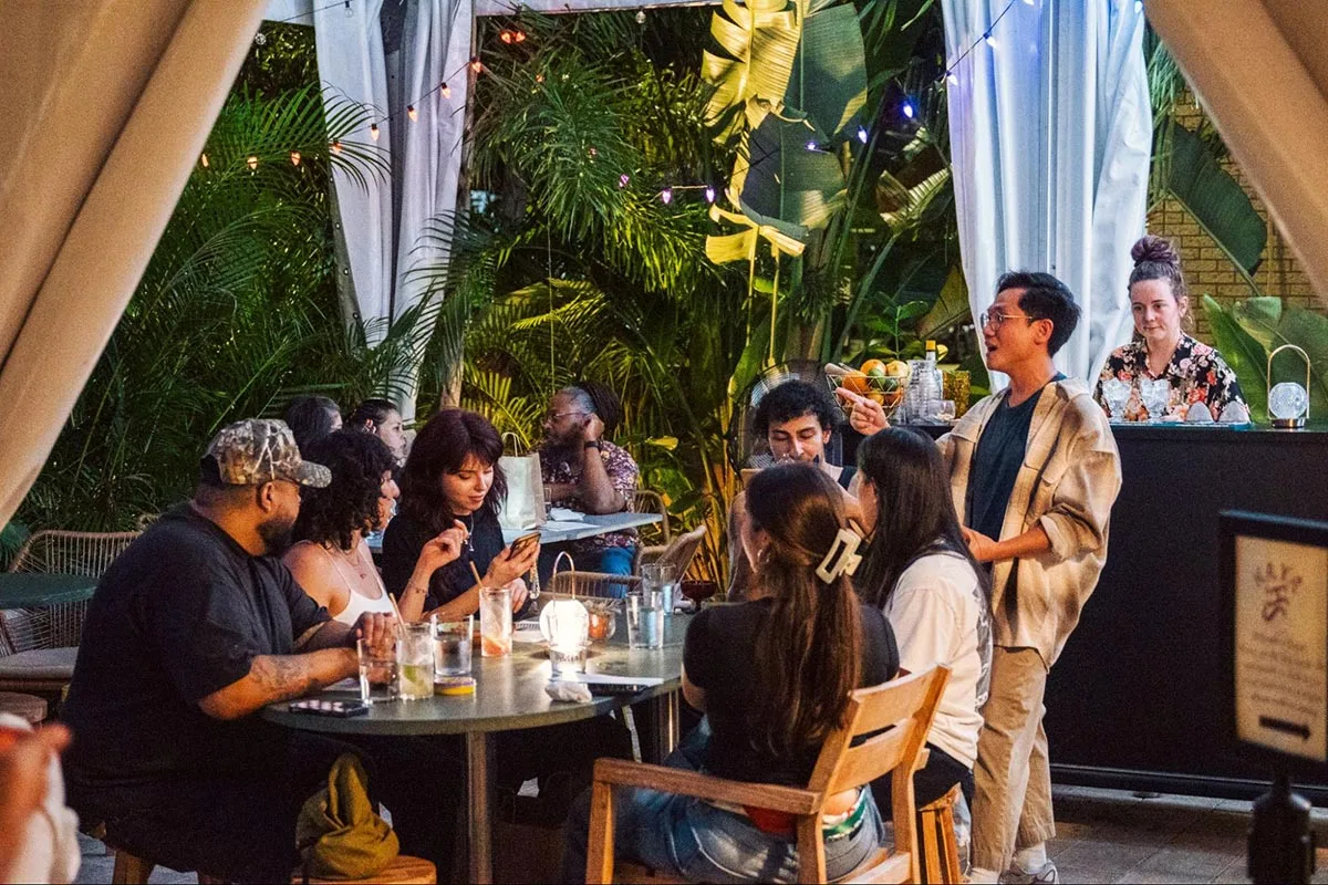 Photo of guests drinking cocktails at Kaya's lush, outdoor patio space known as Bayani Bar from Raphael Loquellano.