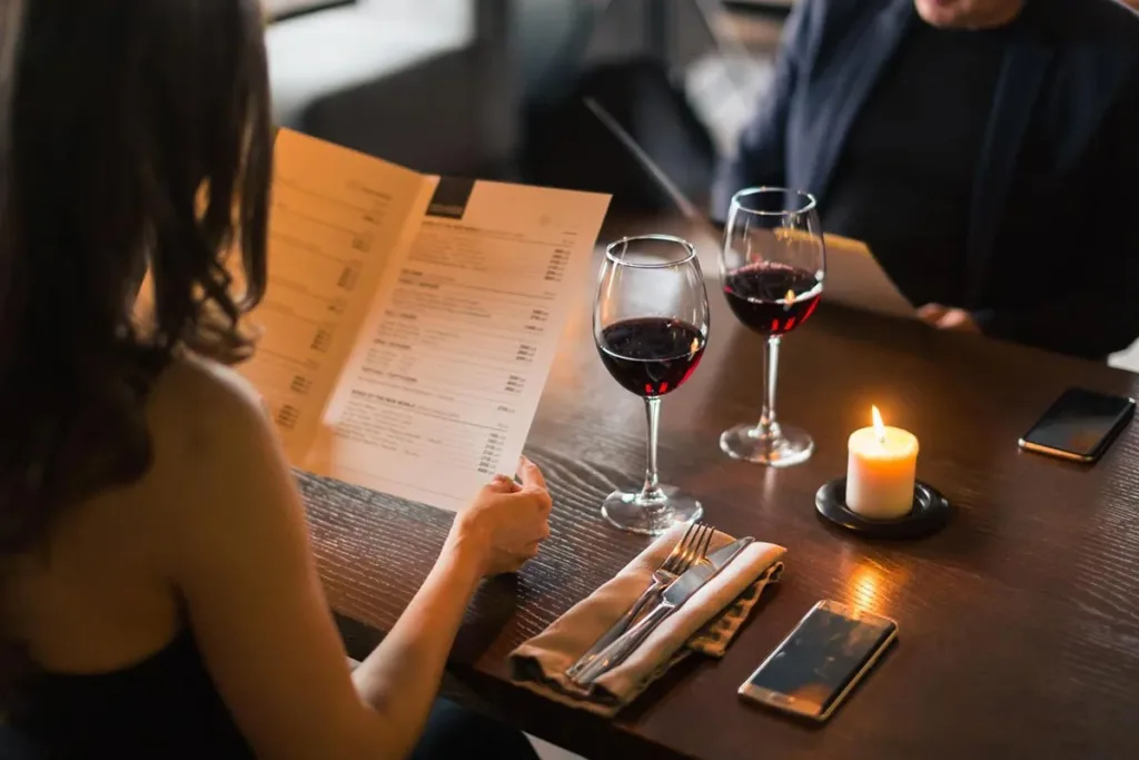 A couple enjoying glasses of red wine at a restaurant.