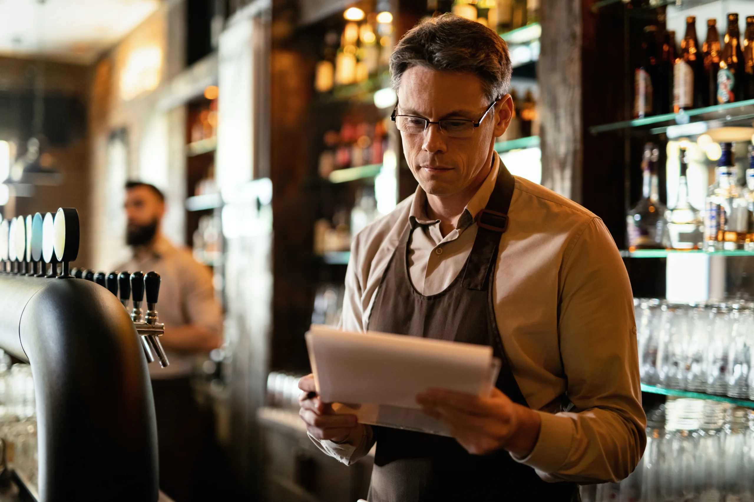 Bar worker with checklist