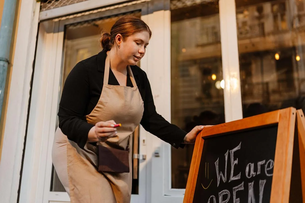 Restaurant owner updating the signage outside their restaurant to attract more customers.