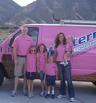 Photo of Angie and Ryan Snow, co-owners of Western Heating & Air Conditioning, posing with their children in front of a branded truck.