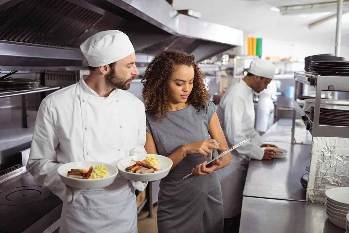 Restaurant manager and chef discussing health and food safety procedures.