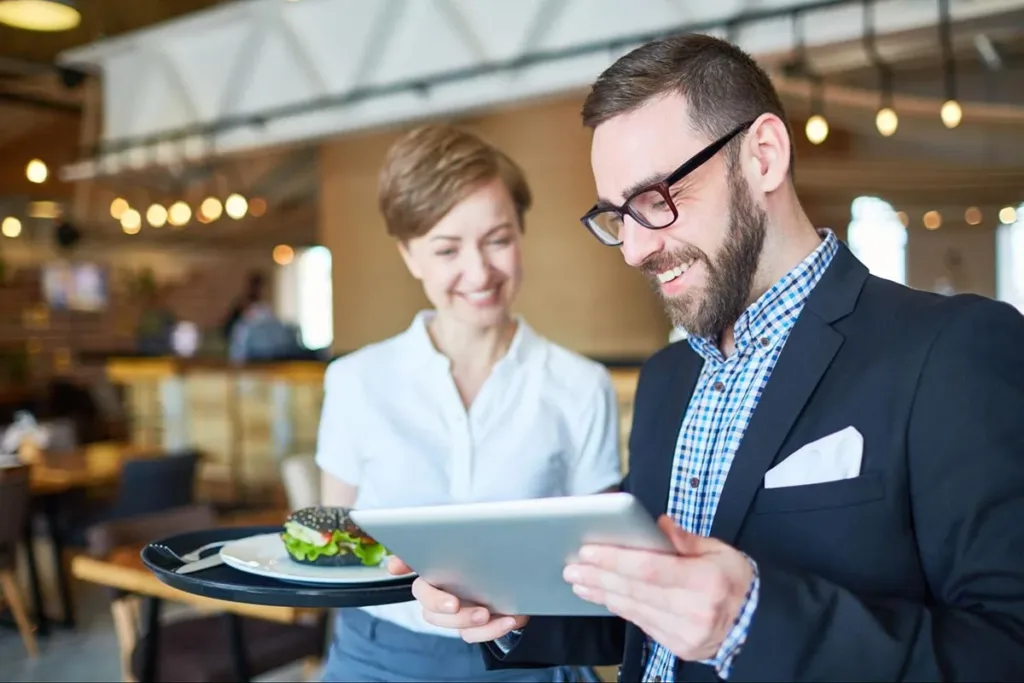 A restaurant manager using a tablet to manage operations.