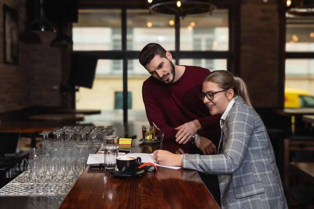 Restaurant owners are having a discussion about food costs at a table.
