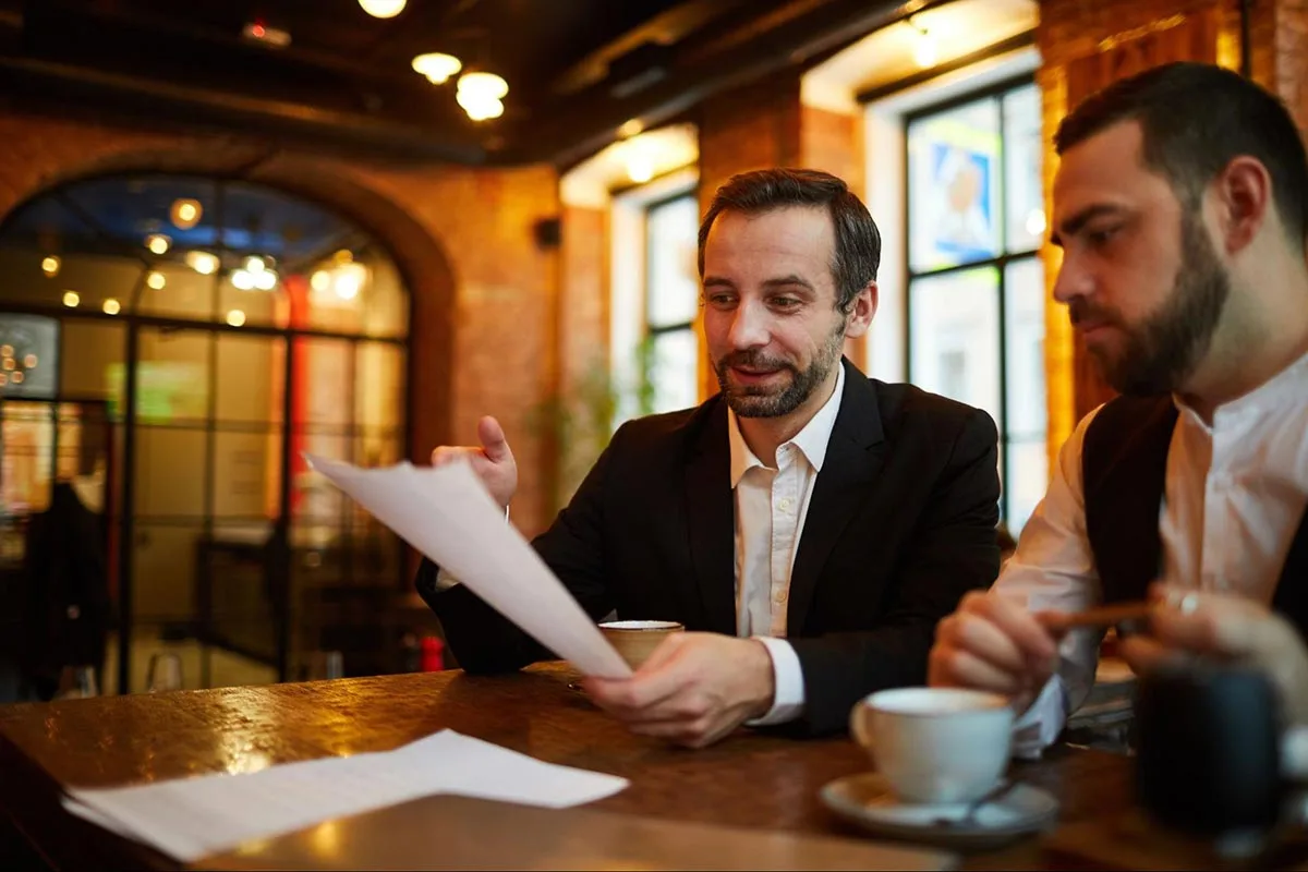 Restaurant team gathered together reviewing a flyer to promote a special offer.