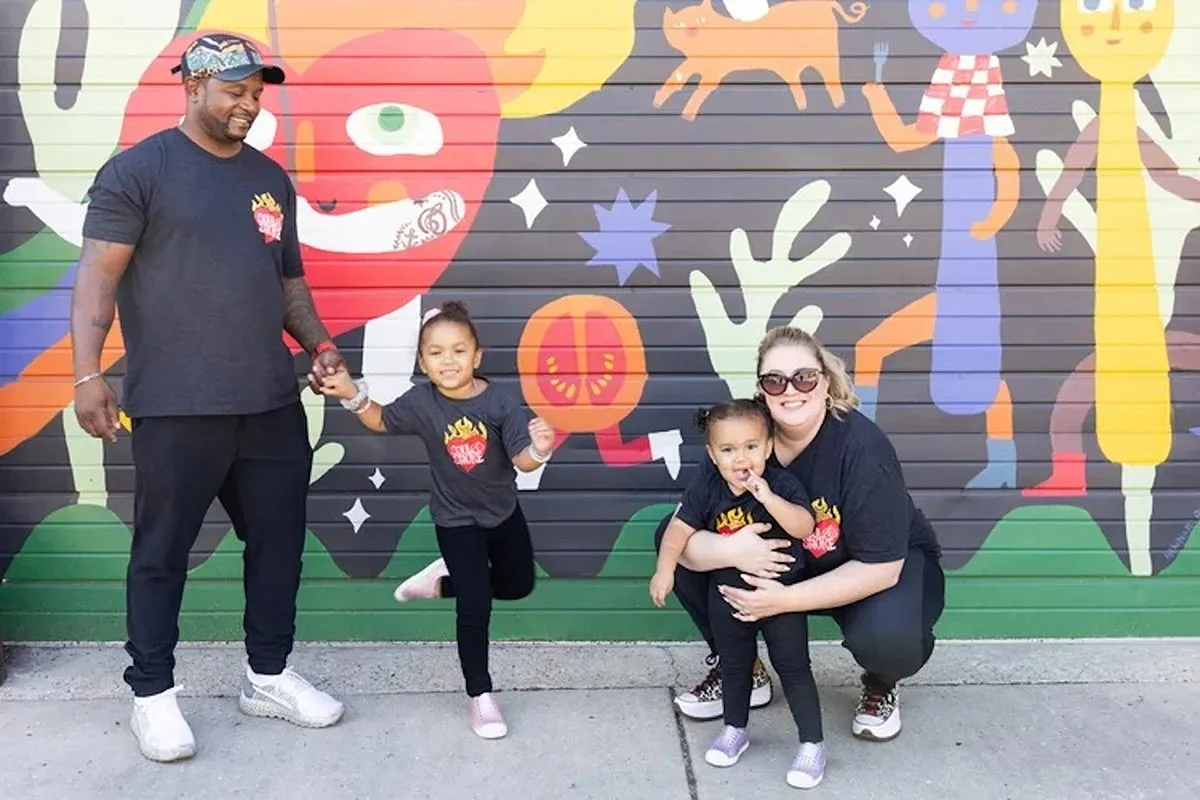 Soul & Smoke co-founders D’Andre Carter and Heather Bublick pose with their children in Soul & Smoke t-shirts.