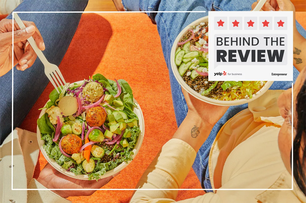 Photo of two people holding salad and grain bowls from CAVA.