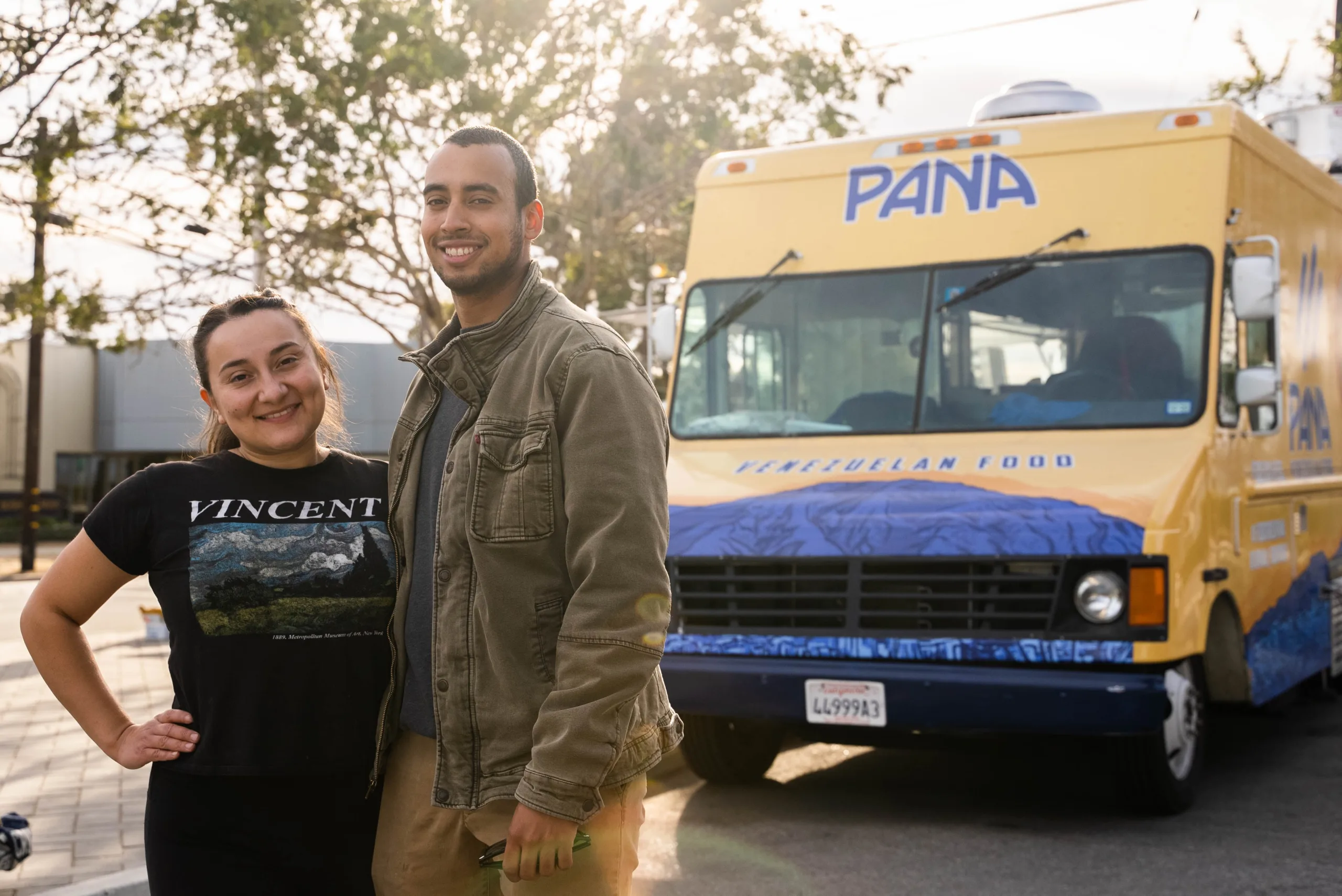 Photo of Pana co-owners Gabriella Ramirez and German Sierra posing in front of a Pana Food Truck.