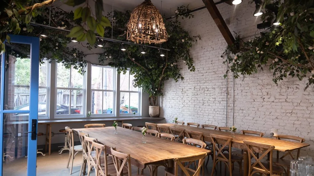 Photo of communal tables and floor-to-ceiling flowers at the Georgetown location in Washington, D.C. from Maman on Yelp.