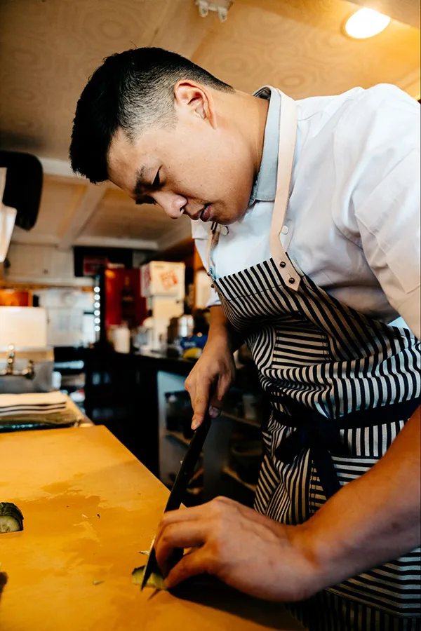 Photo of Tatsumi Sushi's executive chef, Elvin Jin, preparing food.