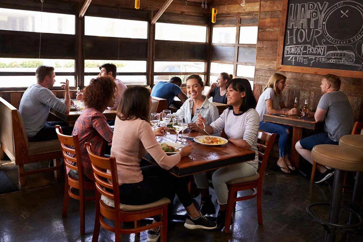 A bustling restaurant dining area filled with guests enjoying their meals.