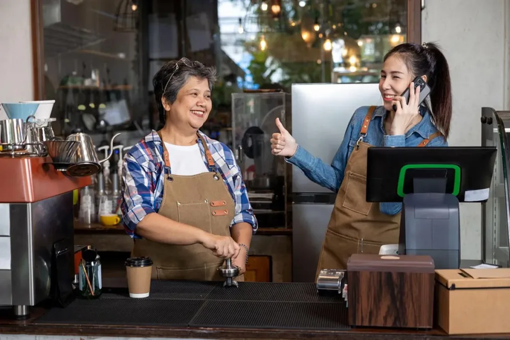 Restaurant manager speaking on the phone with a customer.