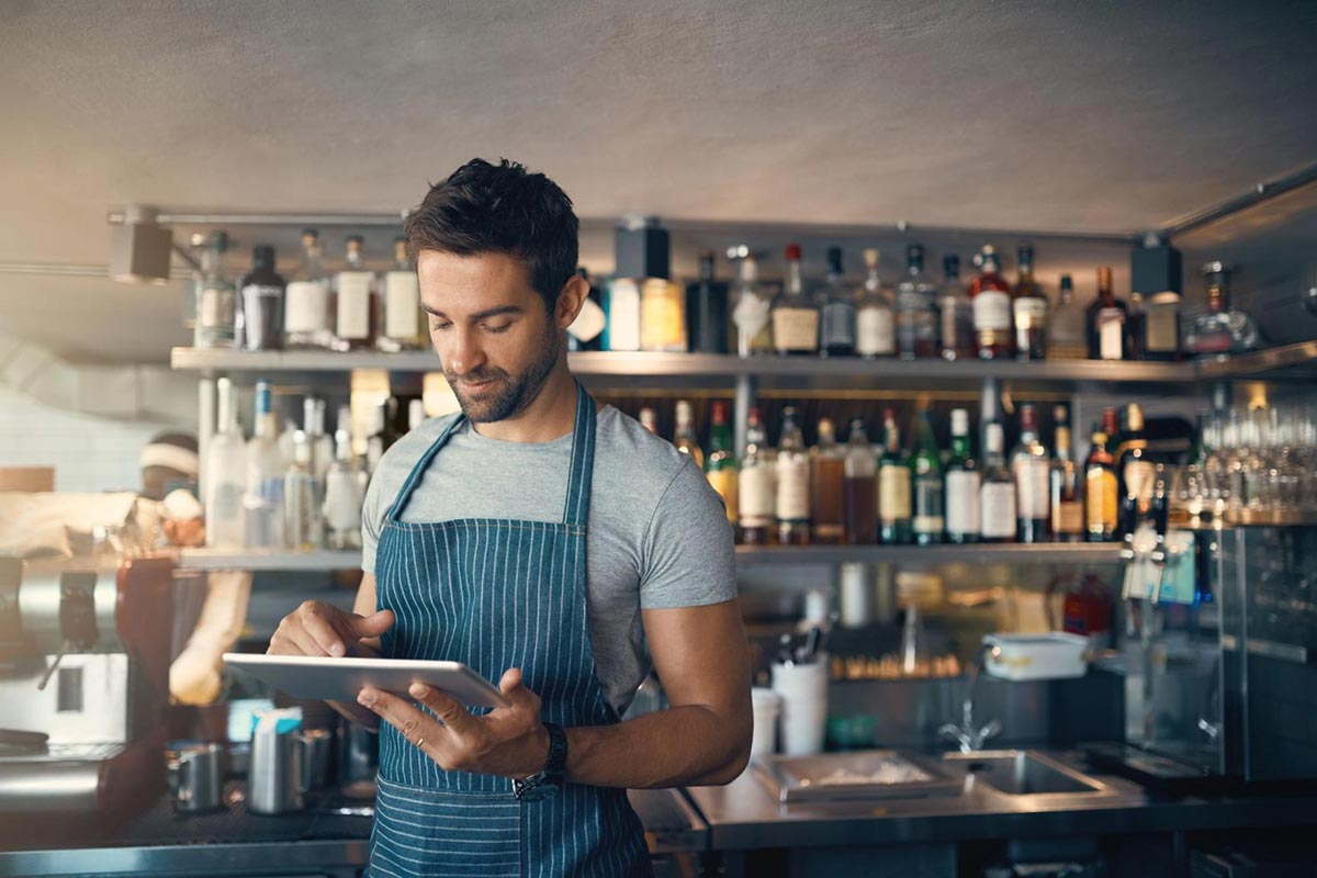 A restaurant manager oversees their business while an AI answering service assists with customer inquiries.